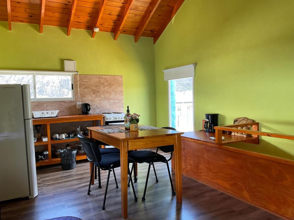 a kitchen with a table and chairs in a room at Cabaña Familia de Campo 2 in El Chalten