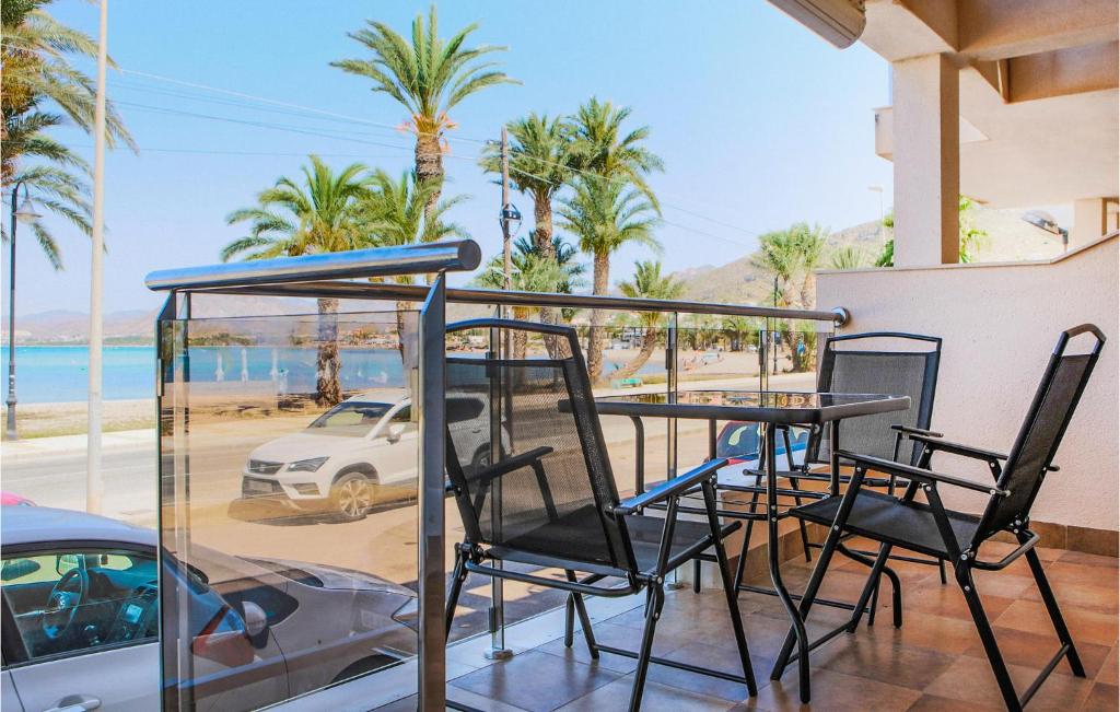 a table and chairs on a balcony with palm trees at Cozy Home In Cartagena With Kitchen in Cartagena