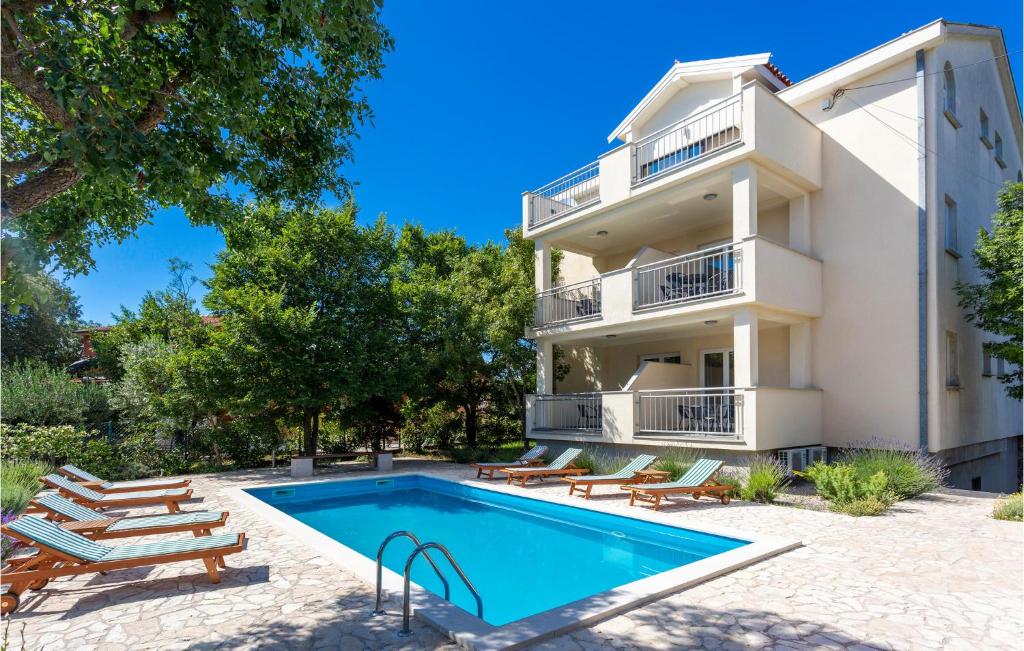 a villa with a swimming pool in front of a building at Beautiful Apartment In Pinezici in Pinezici