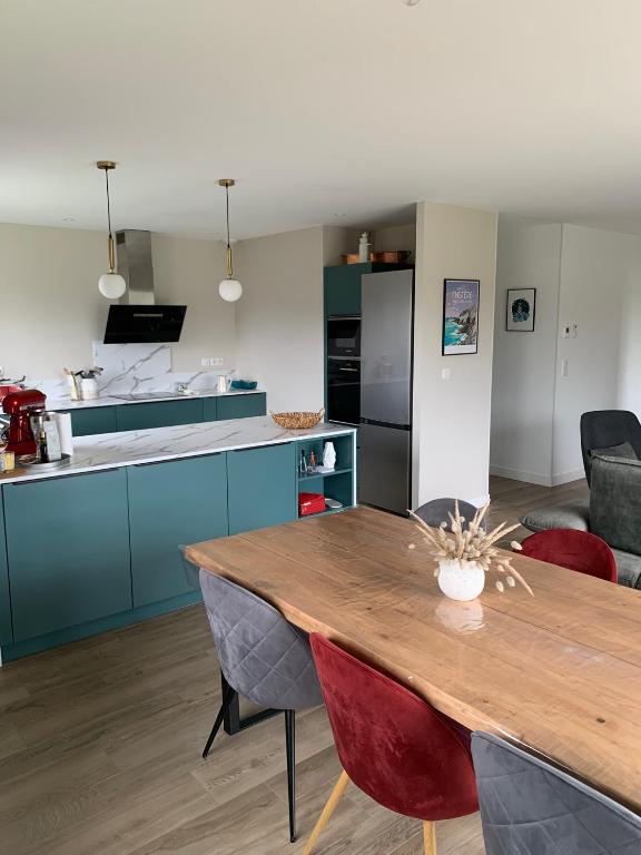 Il comprend une cuisine et une salle à manger avec une table en bois. dans l'établissement Amzer Zo Loctudy, à Loctudy