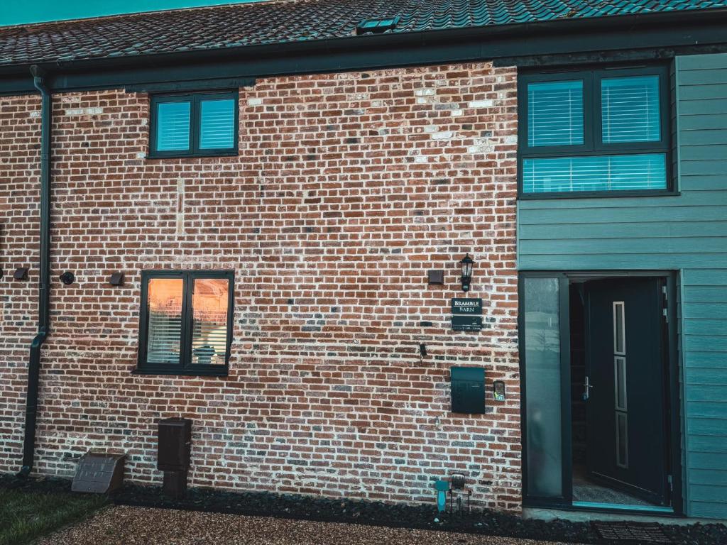 a brick building with blue windows and a door at Bramble Barn Carlton Colville Lowestoft 8 Guests in Carlton Colville
