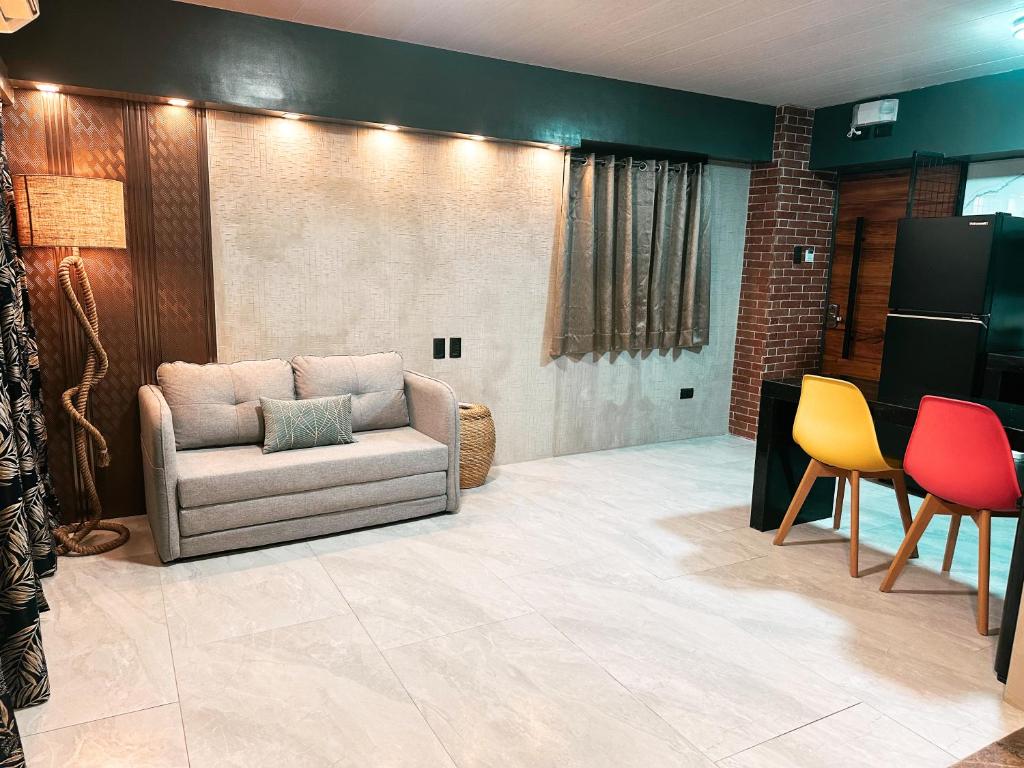 un soggiorno con divano e alcune sedie di Blue Tulip - Rooms with Jacuzzi a Lapu Lapu City