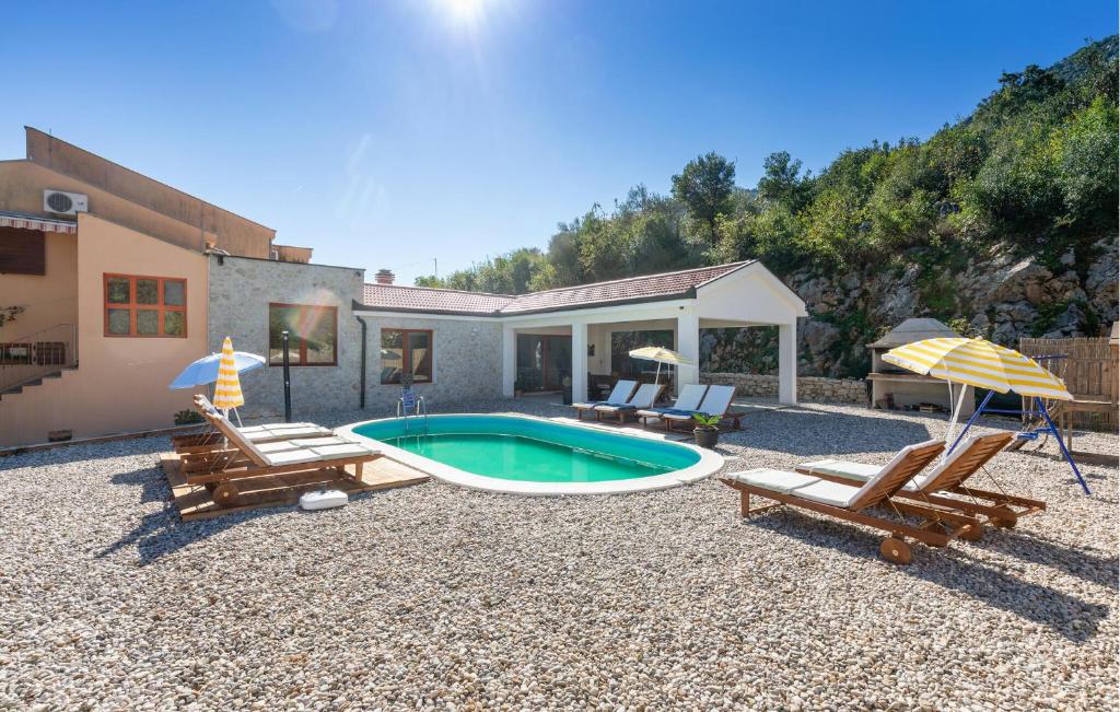 a backyard with a pool and chairs and a house at Amazing Home In Kula Norinska With Wifi in Kula Norinska