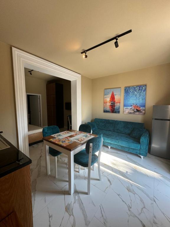 ZverneciVilla Shehu的客厅里有一张桌子和一张蓝色沙发