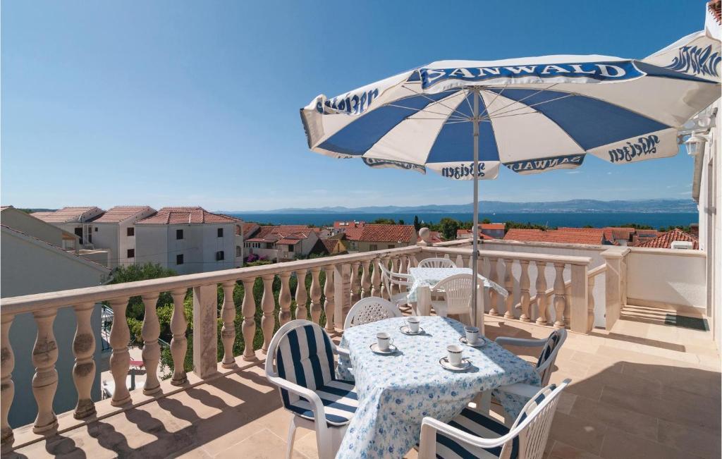 een tafel met een parasol op een balkon bij Three-Bedroom Apartment In Supetar in Supetar