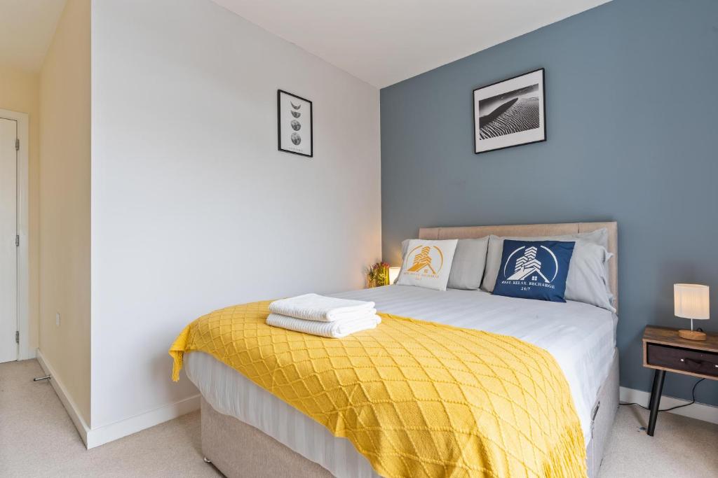 a bedroom with a bed with a yellow blanket at Tranquil Telford Retreat with 2 Bedrooms in Telford