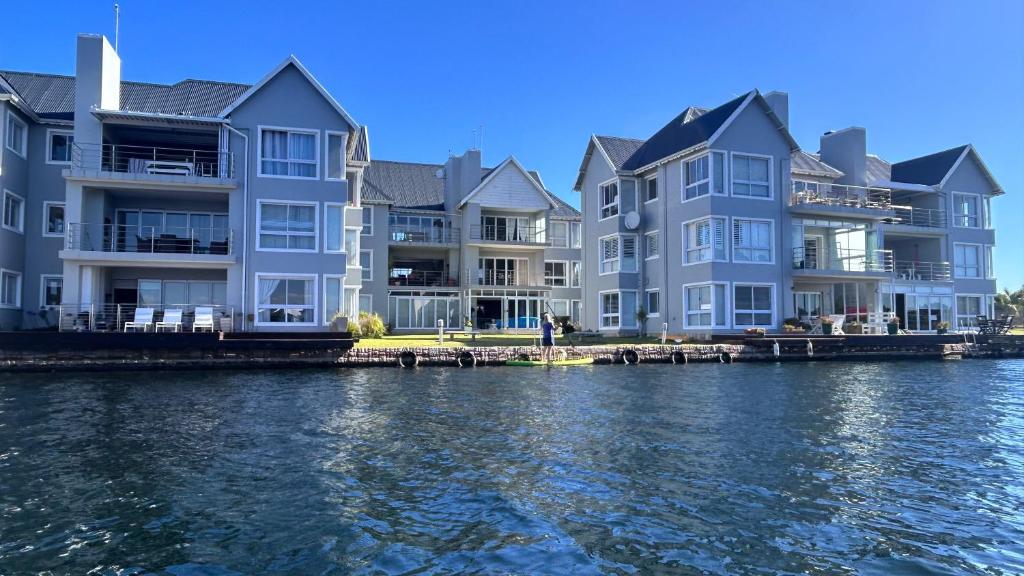 a row of apartment buildings on the water at Marina View Guest House in Jeffreys Bay