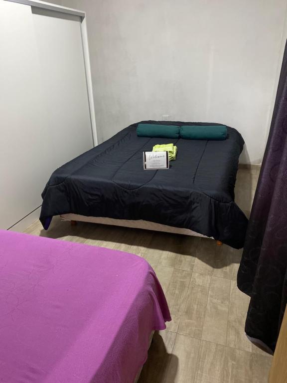 Un dormitorio con una cama con un cartel. en Alquiler, en Colonia Las Rosas