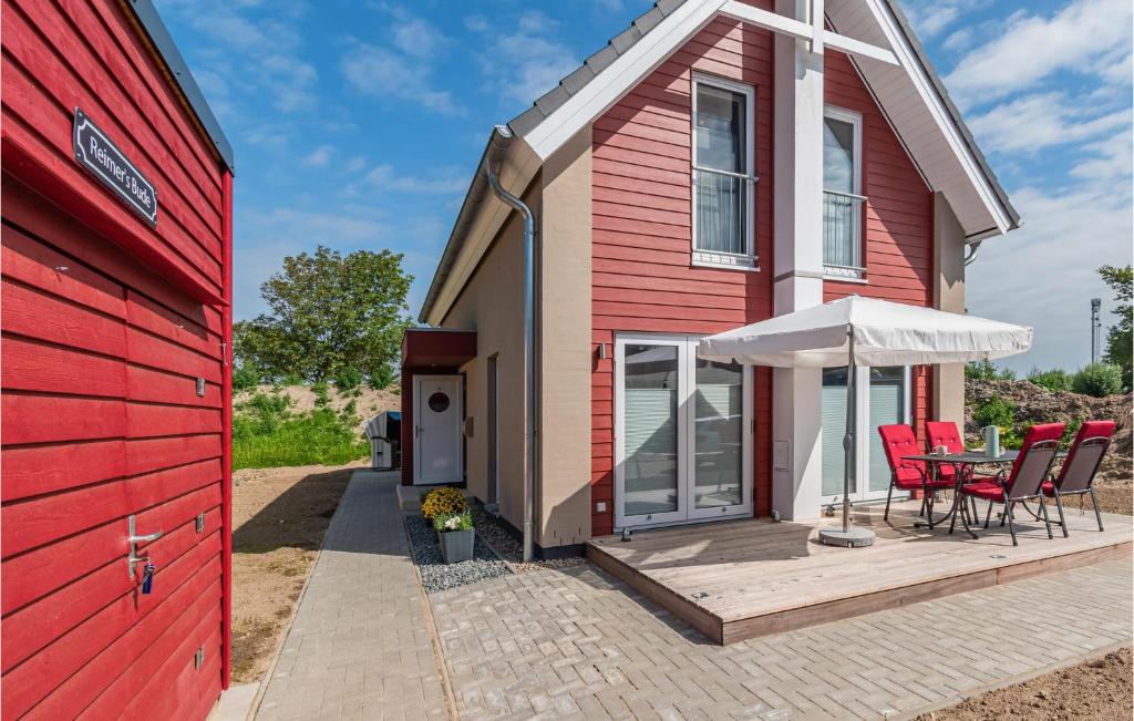 un granero rojo con una mesa y sillas en una terraza en Cozy Home In Büsum With Wifi, en Büsum