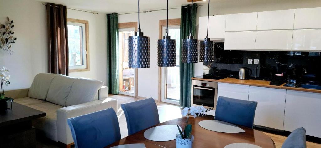 a kitchen and dining room with a table and blue chairs at Vila Veri 2 in Ostrava
