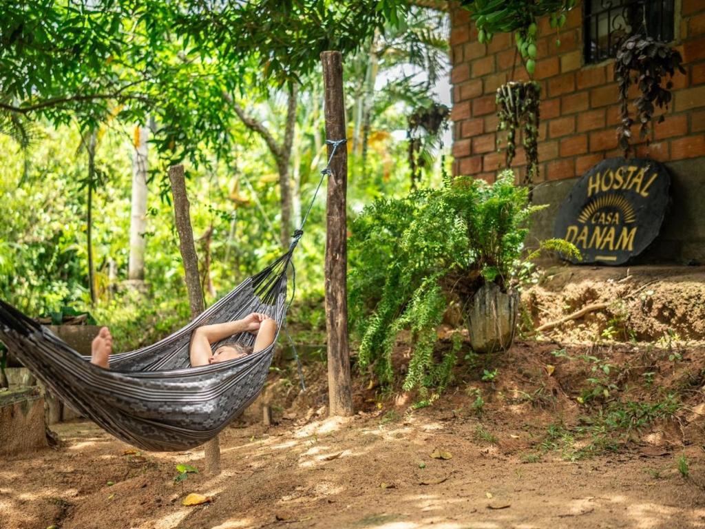 a woman laying in a hammock in a garden at Casa Danam in Santa Marta