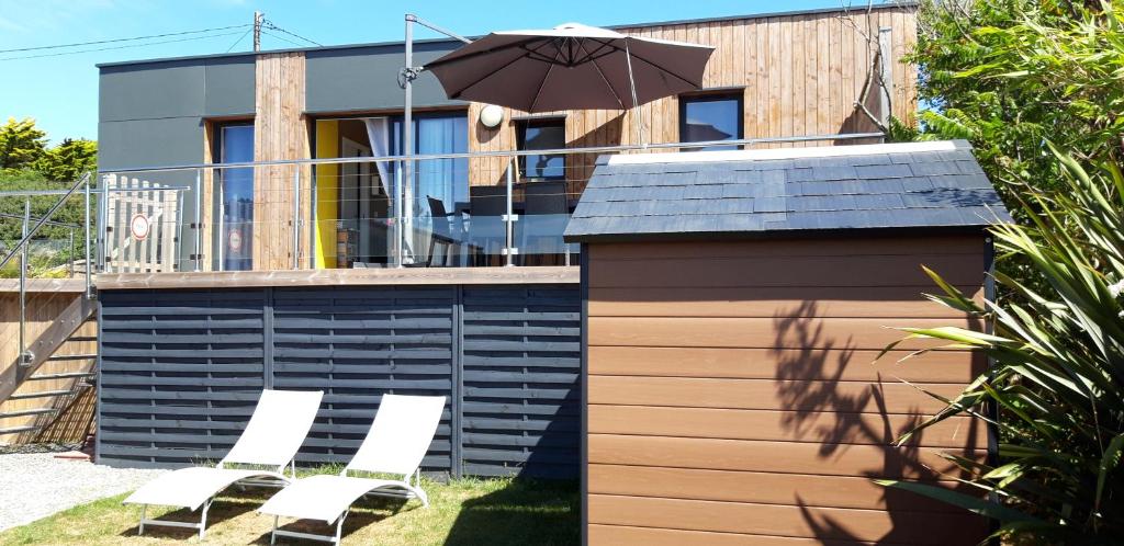 - un groupe de chaises et un parasol sur une maison dans l'établissement L'Escale d'Héol, à Saint-Gildas-de-Rhuys