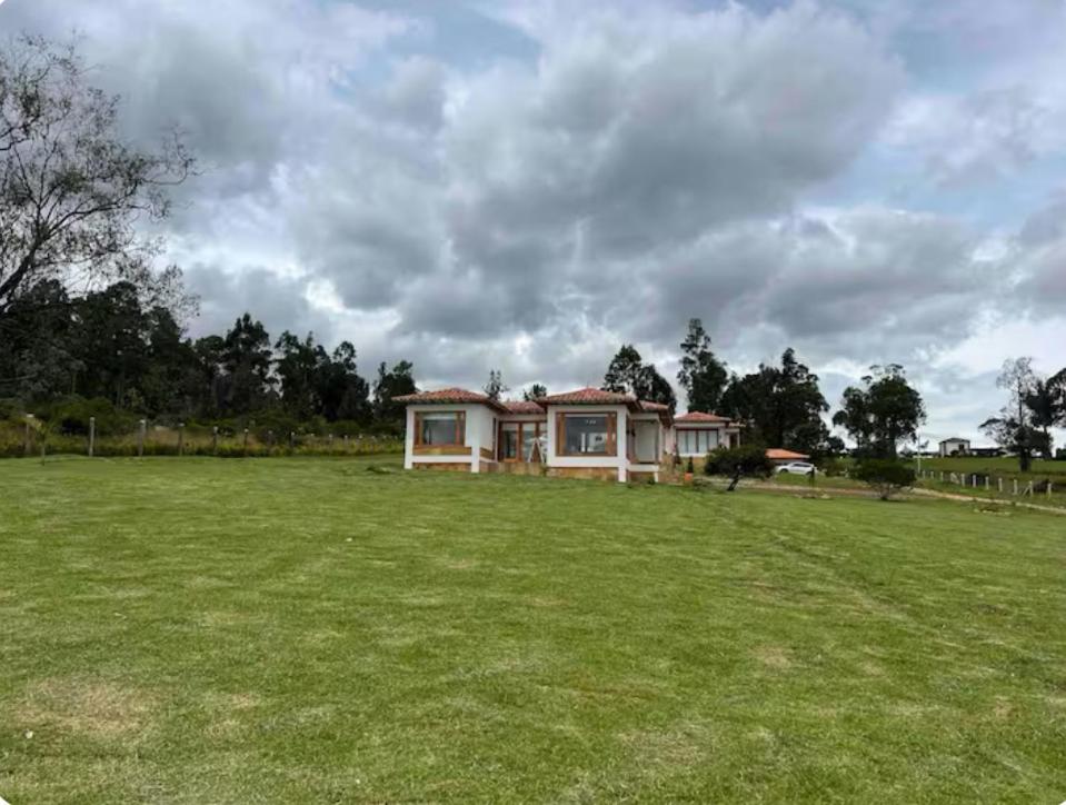una casa en medio de un gran campo de hierba en CasaBlanca2, en Villa de Leyva