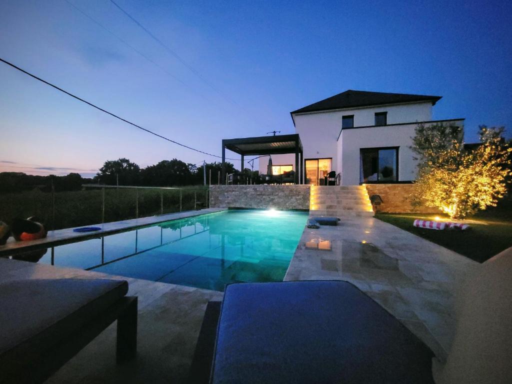 a swimming pool in front of a house at night at Villa Croisette in Pruillé-le-Chétif