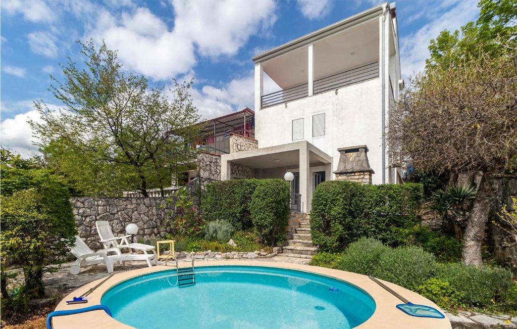 a house with a swimming pool in front of a house at 2 Bedroom Cozy Apartment In Jadranovo in Jadranovo