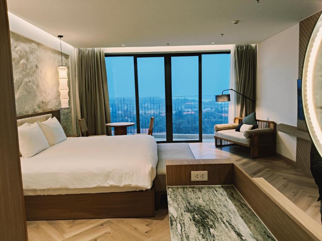 une chambre d'hôtel avec un lit et une grande fenêtre dans l'établissement Luxstay apartment Swimming pools and private beach, à Dien Ban