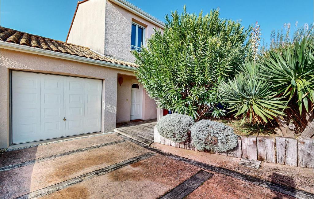 une maison avec une porte de garage blanche et quelques plantes dans l'établissement Beautiful Home In Royan With Wifi, à Royan