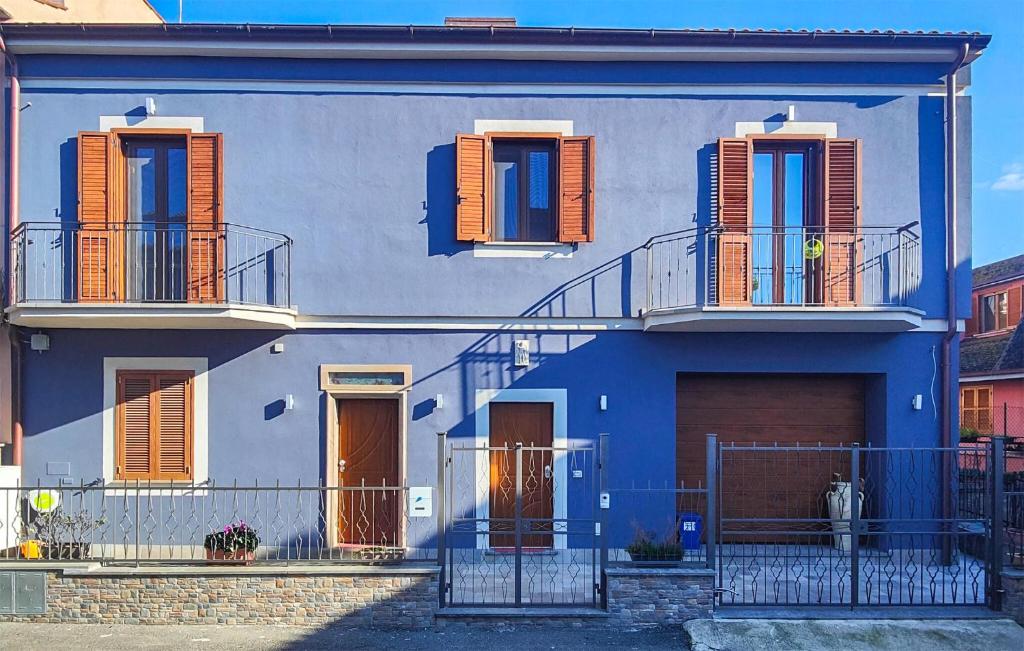 a blue house with orange shutters and a balcony at 1 Bedroom Lovely Apartment In Tuscania in Tuscania