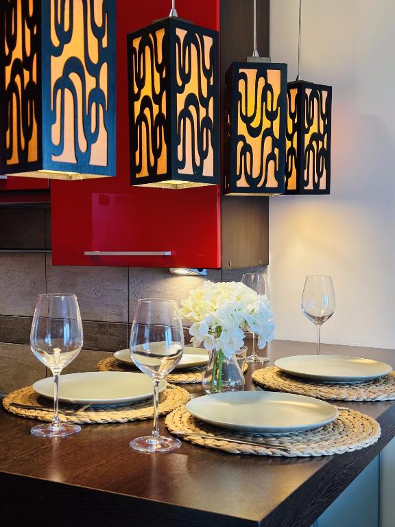 a dining room table with glasses and chandeliers at LUX apartament in Warsaw