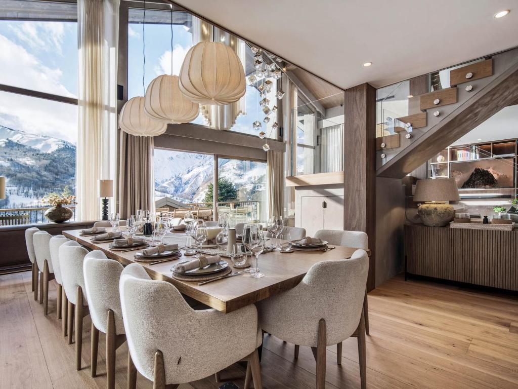 une salle à manger avec une longue table et des chaises dans l'établissement Chalet d'exception avec sauna, piscine chauffée et salle de cinéma - FR-1-570-64, à Saint-Martin-de-Belleville