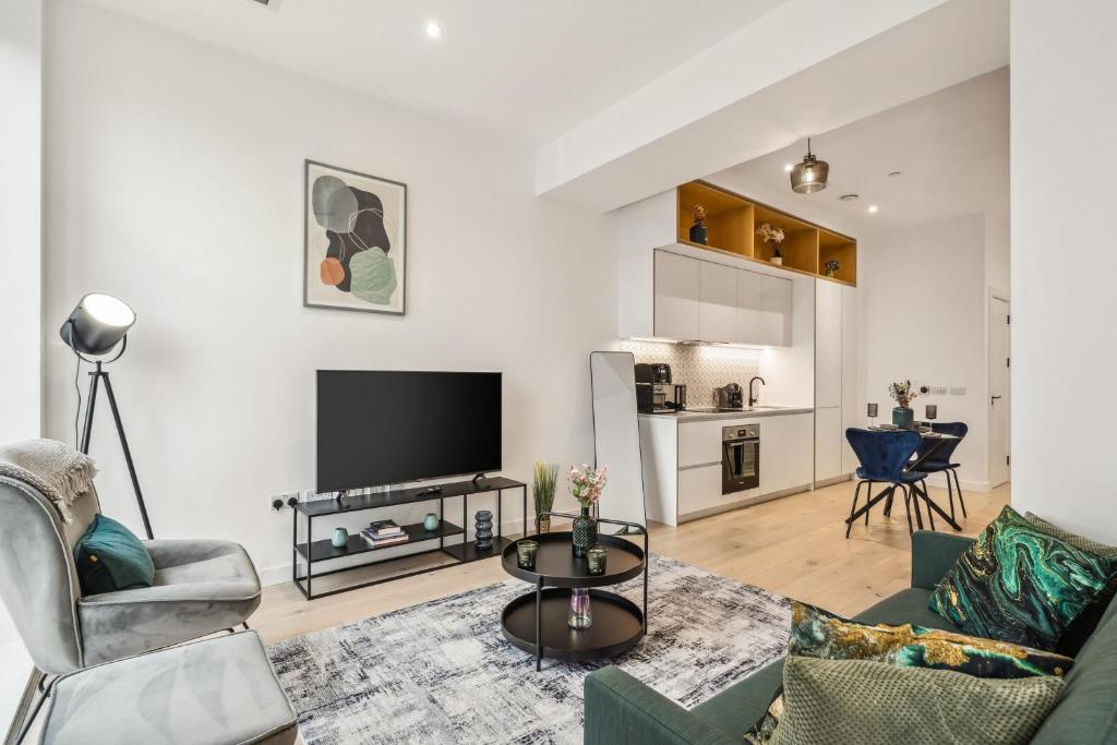 a living room with a couch and a tv at Ultra-Luxury Modern Apartment with Gym, Cinema, Game Room and Parking in Kew Bridge
