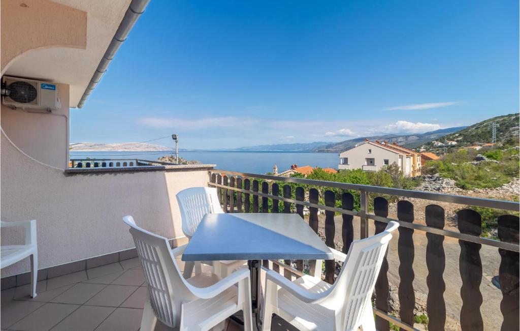 a table and chairs on a balcony with a view of the water at 4 Bedroom Nice Apartment In Sveti Juraj in Sveti Juraj