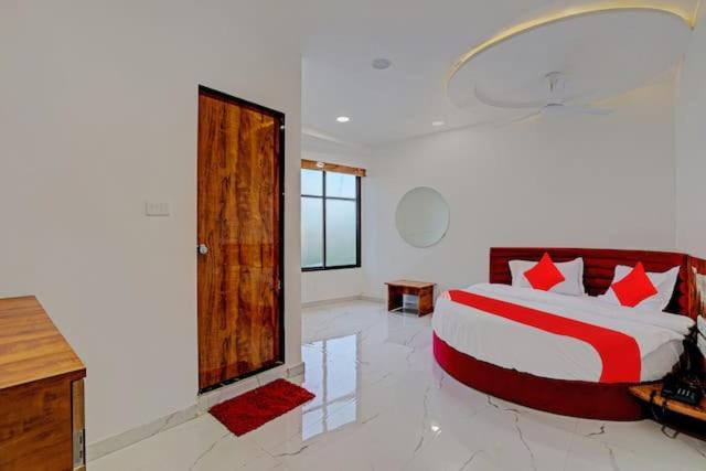 Un dormitorio con una cama grande con almohadas rojas. en Hotel gk villa, en Ahmedabad