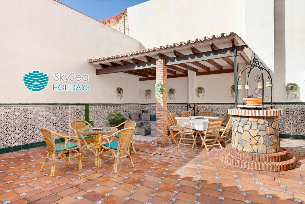 un patio con tavolo, sedie e camino di Casa TIPICA MALAGUEÑA con PATIO en el centro a Málaga