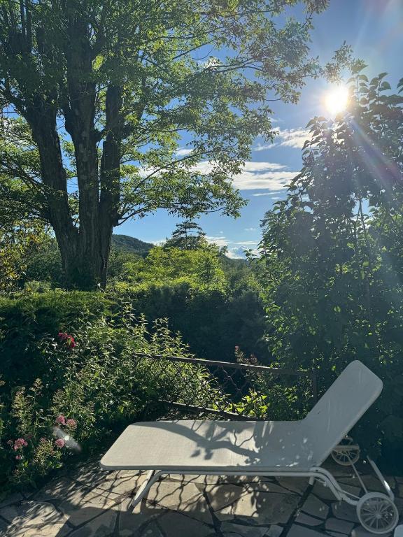 une chaise blanche assise sur une terrasse bien exposée dans l'établissement Grande maison avec jardin et son accès privé à la rivière Drôme, à Mirabel-et-Blacons