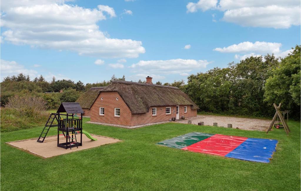 a playground in front of a house with a building at Beautiful Home In Ulfborg With Sauna in Øby