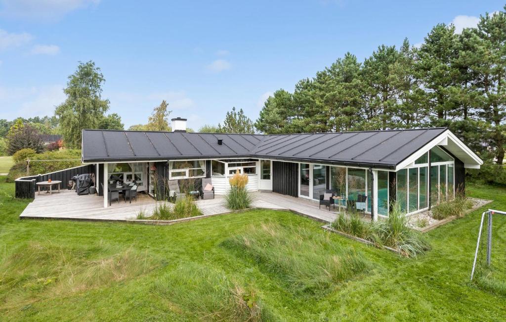 a house with a metal roof on a lawn at Gorgeous Home In Knebel With Sauna in Skødshoved Strand