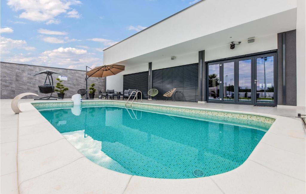 a swimming pool in front of a house at Awesome Home In Koritna With Sauna in Koritna