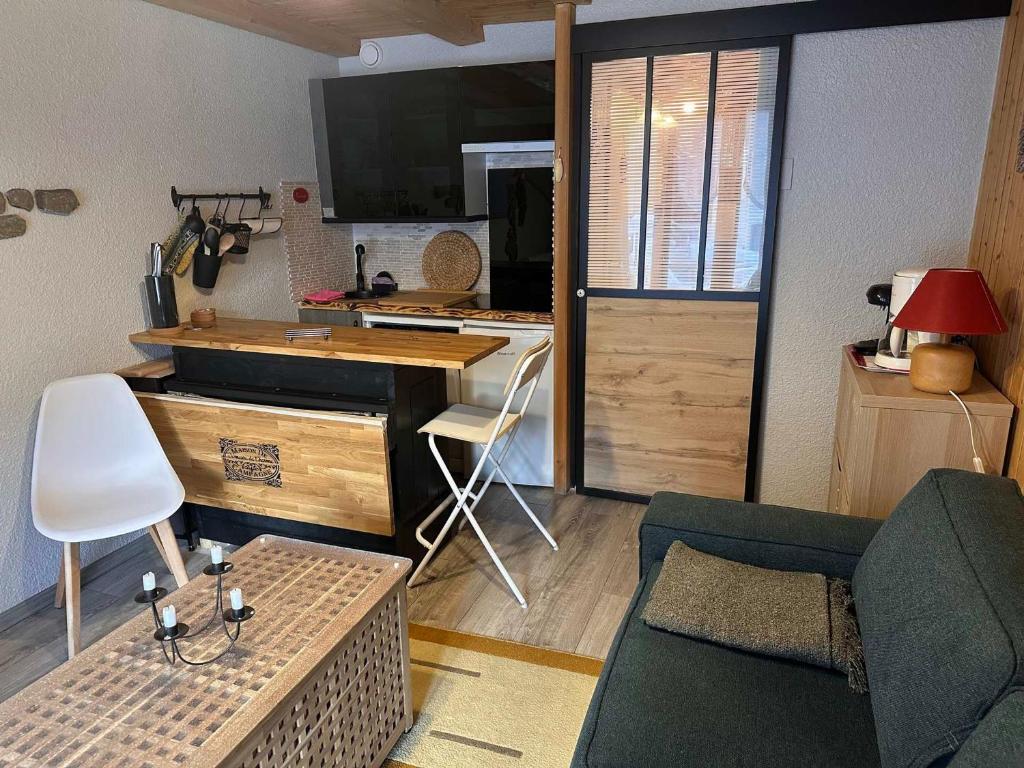 un salon avec un canapé et une cuisine dans l'établissement Studio confortable avec grande terrasse ensoleillée, proche commerces et téléphérique. - FR-1-464-2, à Pralognan-la-Vanoise