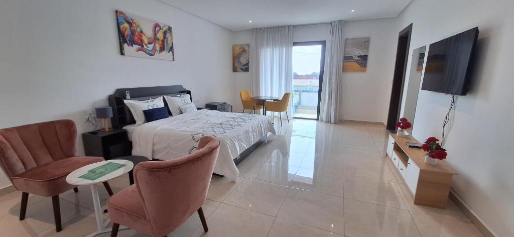 Un dormitorio con una cama y una mesa y sillas. en les Résidences Lorenzini, en Yamoussoukro
