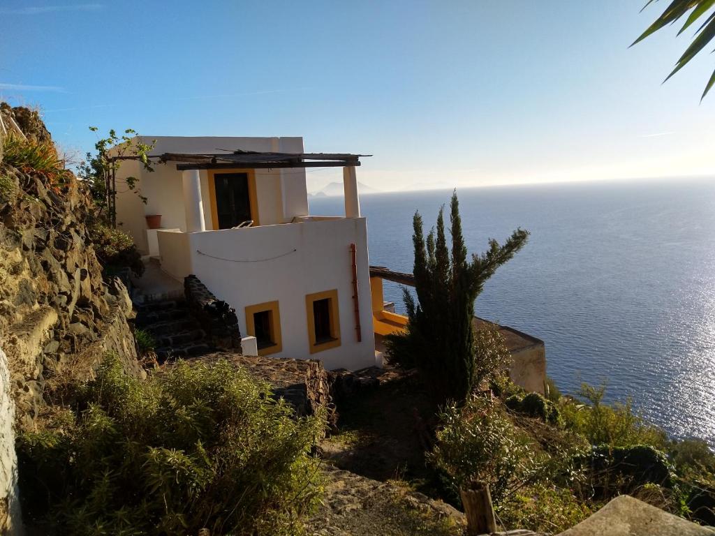 a house on a cliff next to the ocean at Casa al Vallone in Alicudi