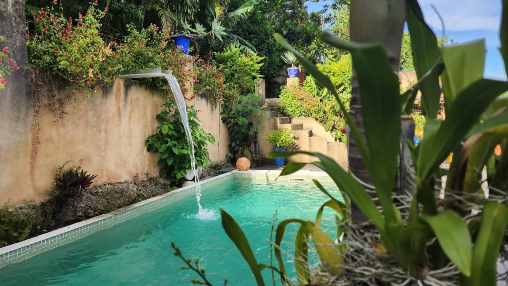 einen Pool mit Wasserfall im Hof in der Unterkunft Nid aigle 3 Suites in Rio de Janeiro