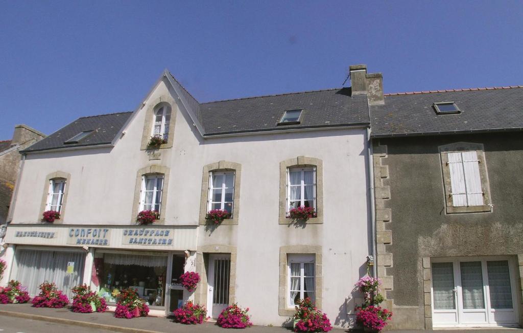 a white building with flowers in front of it at 2 Bedroom Nice Home In Plonevez Porzay in Plonévez-Porzay