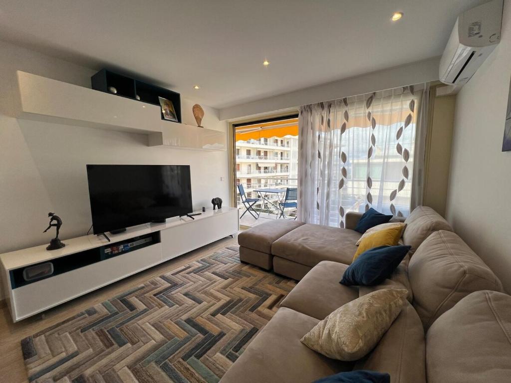 un salon avec un canapé et une télévision à écran plat dans l'établissement Sea view, top floor facing Port Canto in Palm Beach, à Cannes