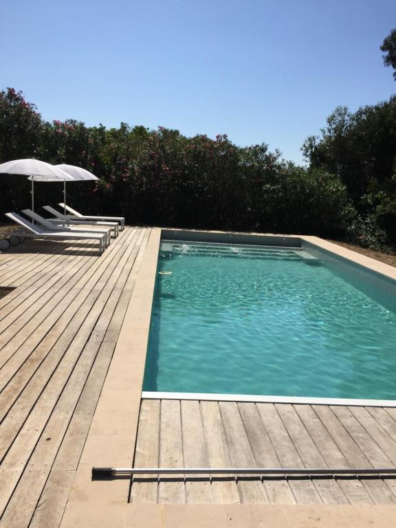 une piscine avec une terrasse en bois et un parasol dans l'établissement Villa Sun&Sea, à La Croix-Valmer