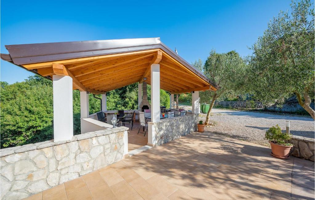 pawilon z drewnianym dachem na kamiennej ścianie w obiekcie 2 Bedroom Beautiful Apartment In Labin w mieście Drenje