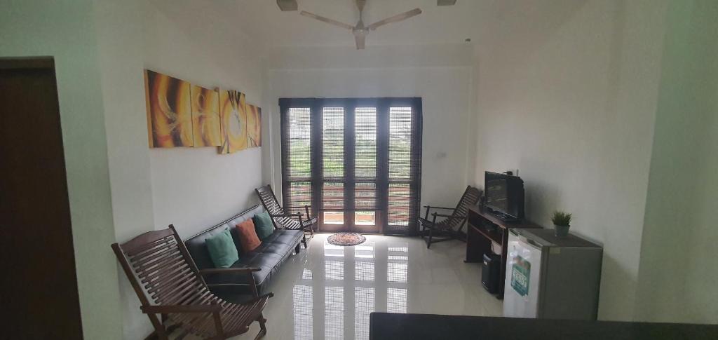 a living room with a couch and a tv at Mount Apartments Colombo in Attidiya