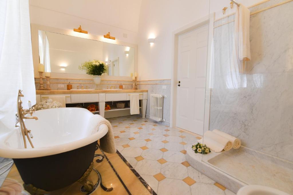 une salle de bain avec une baignoire, un lavabo et une douche dans l'établissement Villa Favorita Luxury - Italia Monopoli Puglia Trullo, à Monopoli