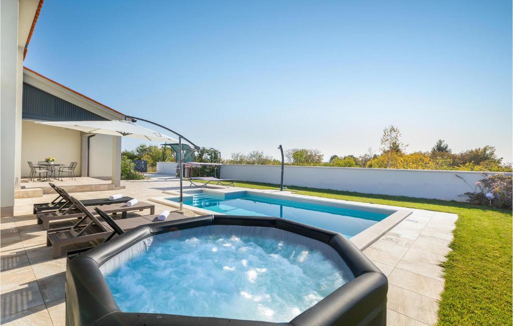 basen na dziedzińcu z krzesłami w obiekcie Awesome Home In Vodnjan w mieście Vodnjan