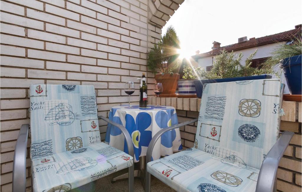 dwa krzesła i stół na patio w obiekcie 2 Bedroom Lovely Apartment In Rovinj w Rovinj