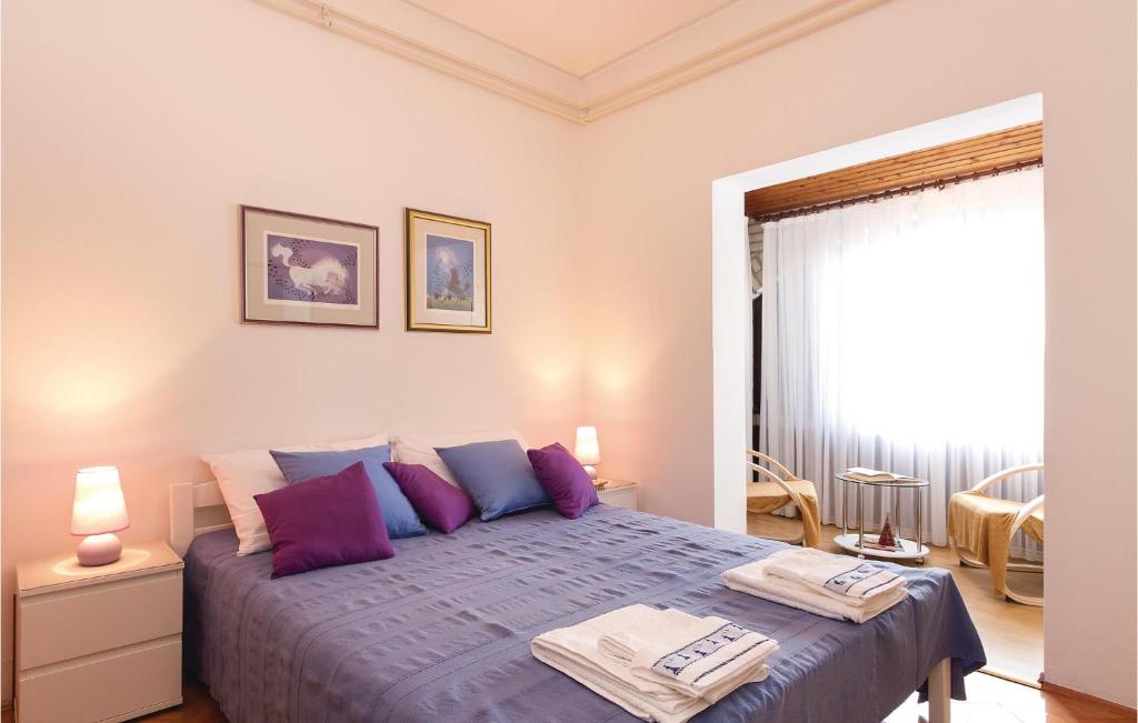 sypialnia z dużym łóżkiem z fioletowymi poduszkami w obiekcie 2 Bedroom Lovely Apartment In Rovinj w Rovinj