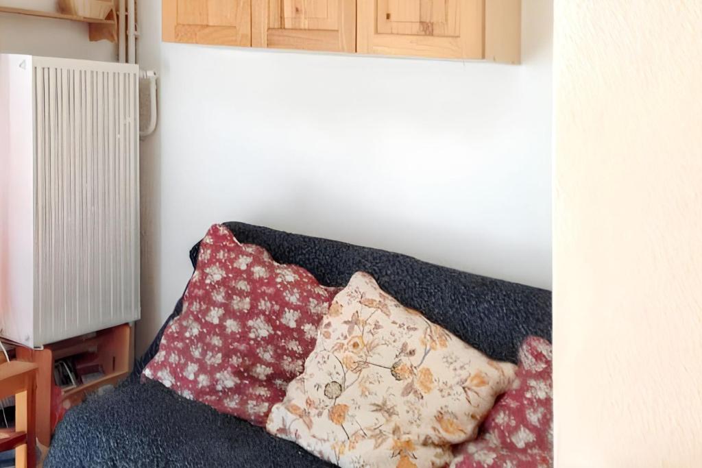- un canapé avec deux oreillers dans l'établissement Studio cosy avec vue sur la montagne - Les Belleville - 20 m², aux Menuires