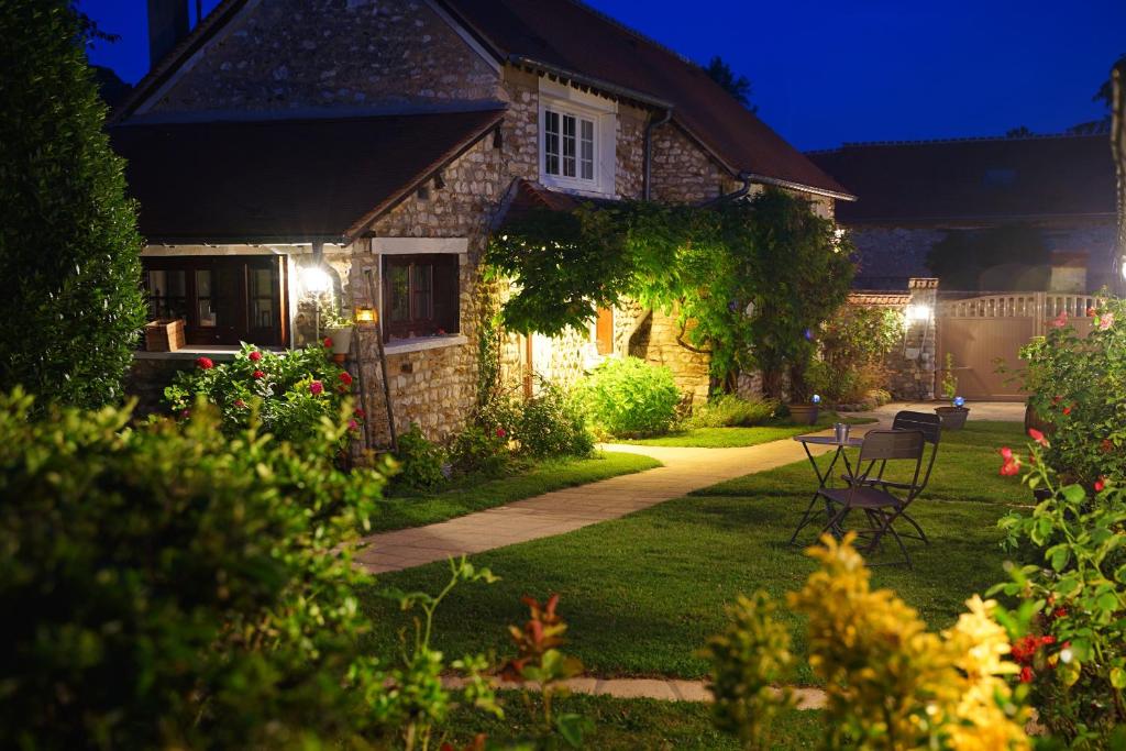 a stone house with a garden at night at A la belle Etoile de Paris à Honfleur in Cravent