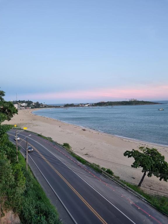 a road next to a beach next to the ocean at Jabuticaba Sabará - Frente ao Mar na Praia de Meaípe, Guarapari in Guarapari