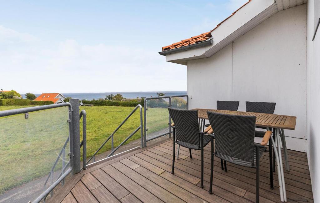 a wooden deck with a table and chairs on it at Gudhjem Søpark Lejl 18 in Gudhjem
