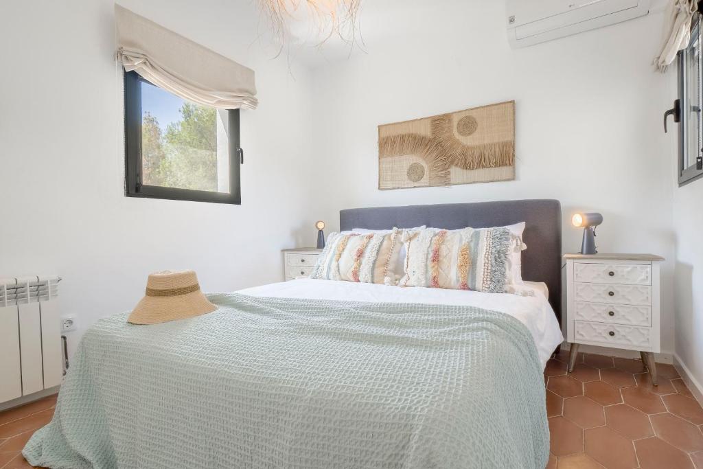a white bedroom with a bed and a window at Villa Tosalet Pomelo in Jávea